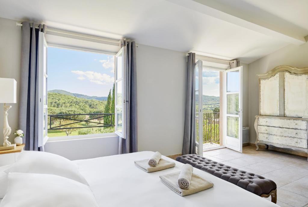 圣特罗佩Golf Resort & Country Club Saint-Tropez的一间卧室设有一张床和一个大窗户