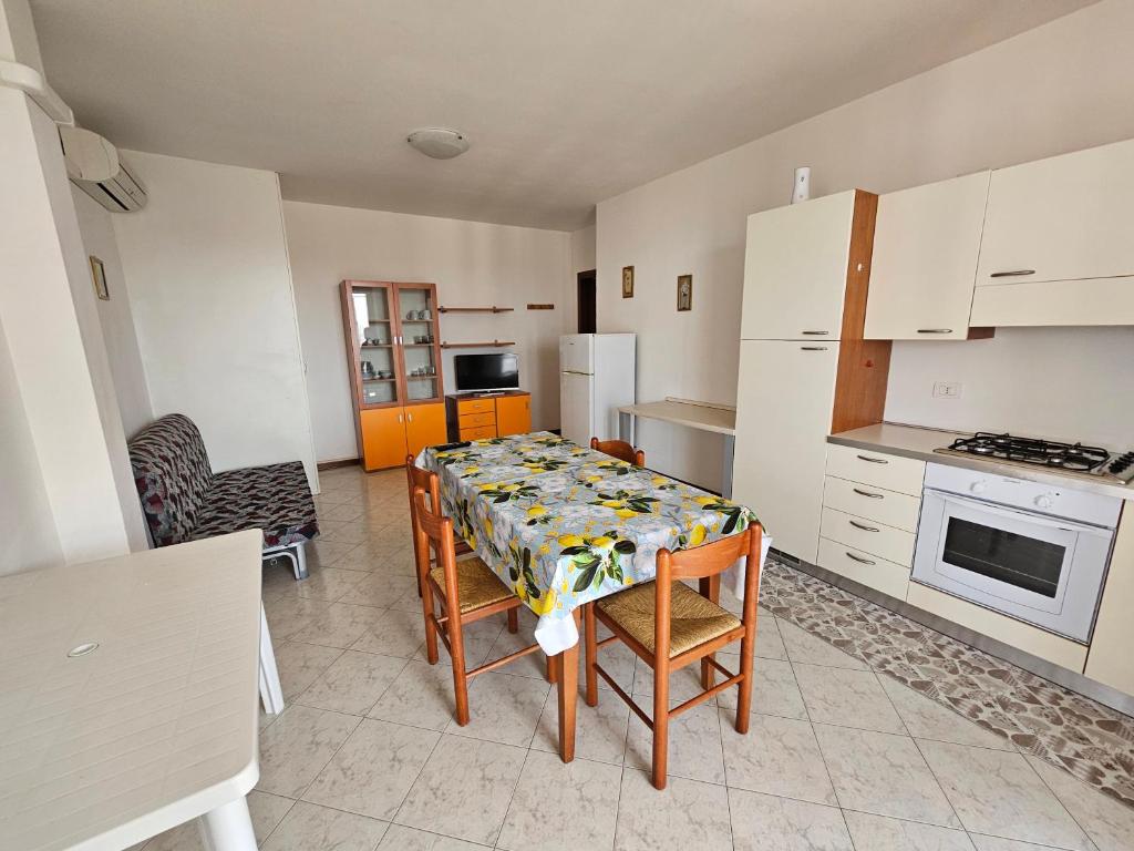 加里波第港Appartamento a Porto Garibaldi vicino al mare的带桌椅的厨房以及带白色家电的厨房。