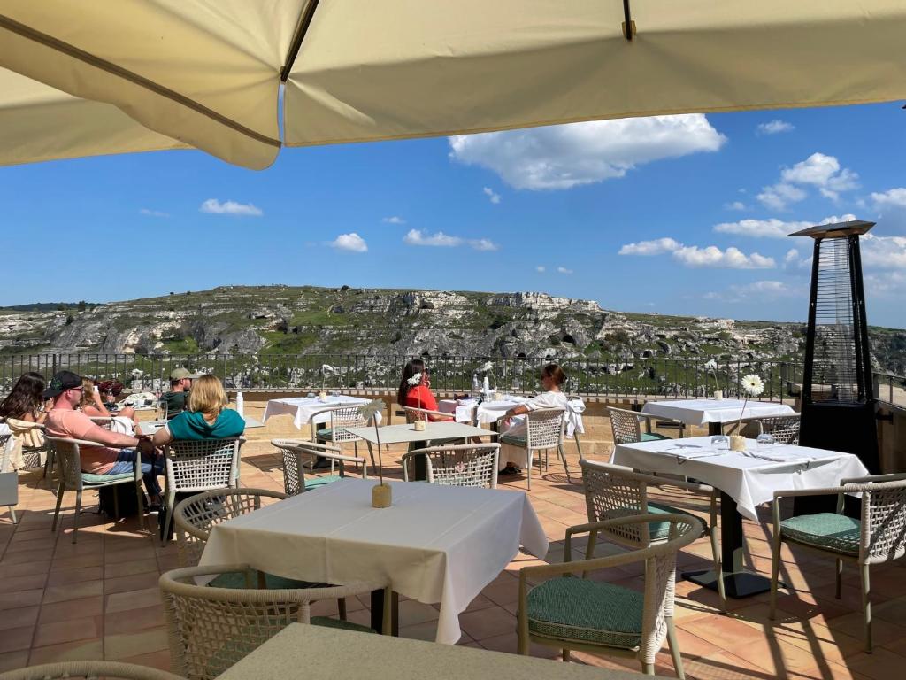马泰拉Quarry Resort的一间设有桌椅的餐厅,享有城市美景