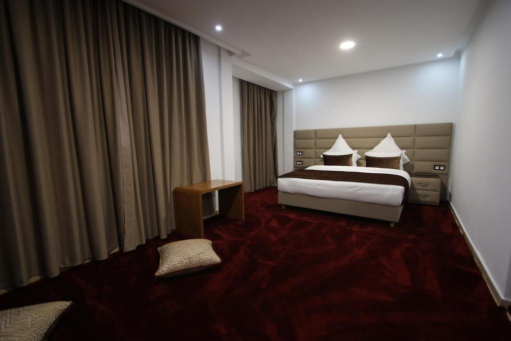 达赫拉Hôtel Mansour的酒店客房配有一张床铺和一张桌子。
