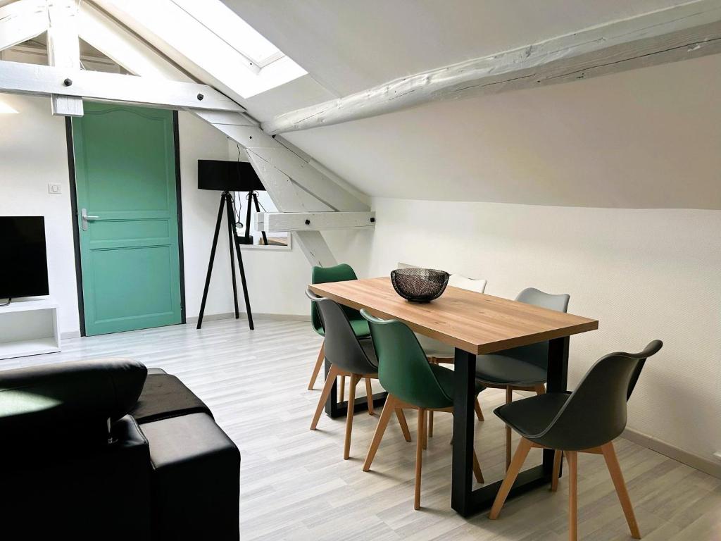 蓬塔穆松Appartement climatisé Le Gambetta的一间带木桌和绿色椅子的用餐室