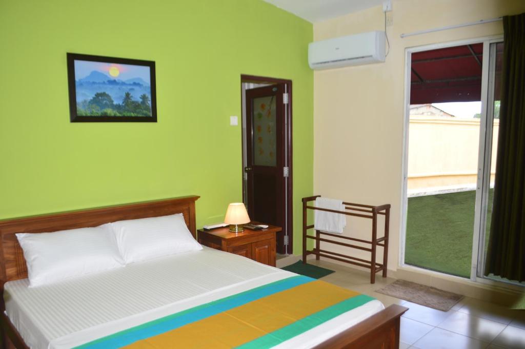 KelaniyaParamount Residence 3的一间卧室设有一张床和一个大窗户