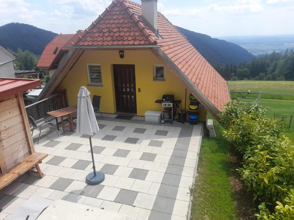 魏茨Ferienwohnung Zetzhirsch的黄色的房子,配有桌子和雨伞