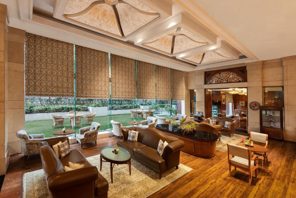 新德里Sheraton New Delhi Hotel的大型客厅配有家具和大窗户