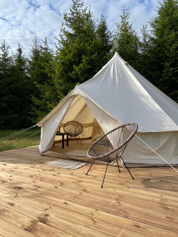 奥泰佩Restu Forrest Glamp的帐篷配有两把椅子、一张桌子和一把椅子