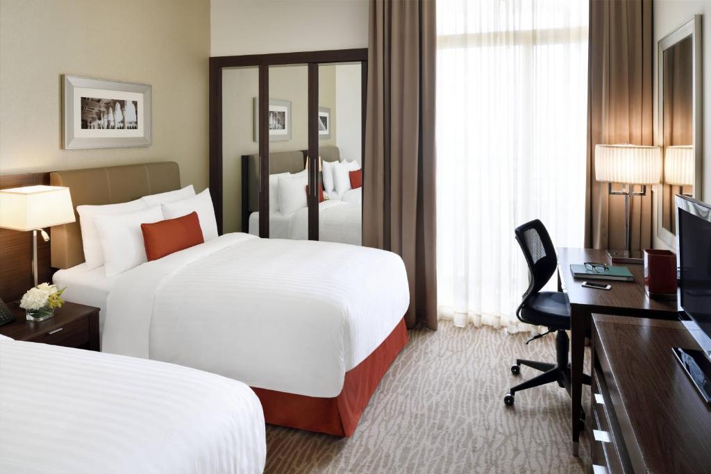 利雅德利雅得会议中心万豪行政公寓式酒店的酒店客房配有两张床和一张书桌