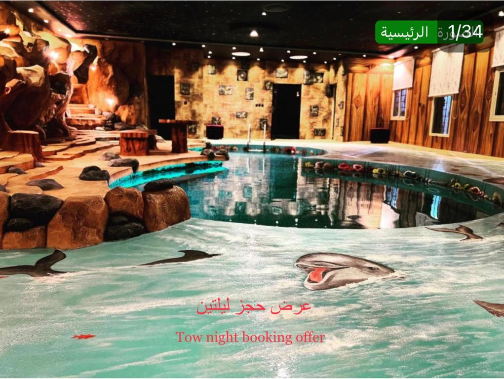 塔伊夫شاليهات ليالي زين الشرف 1的一座大型游泳池,里面的海水里放着海豚