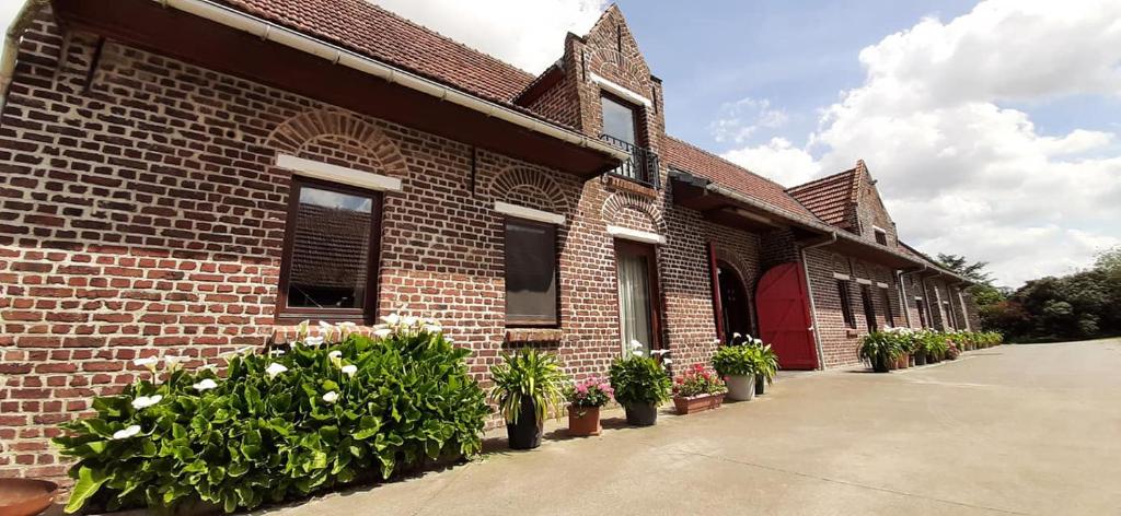 PoelkapelleVarlet Farm的前面有盆栽植物的砖砌建筑