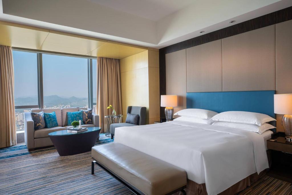 惠州惠州富力万丽酒店的一间带白色大床的卧室和一间客厅
