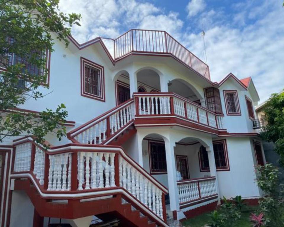 海地角La Difference Guest House的大型白色房屋,设有大甲板