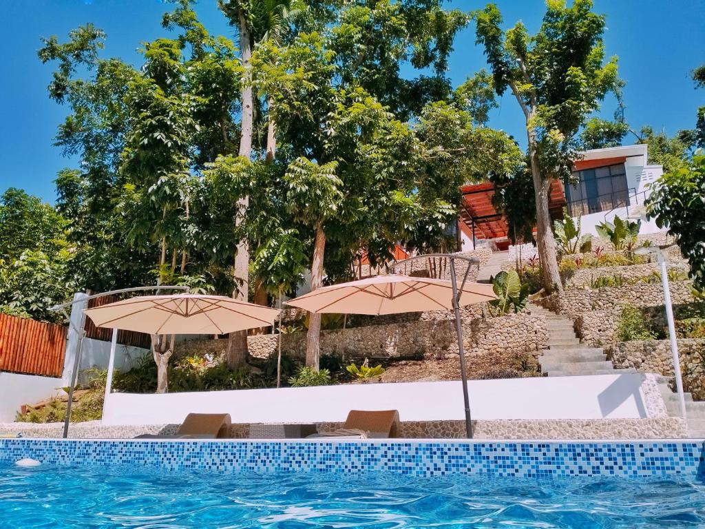 BariliLas Terrazas de Barili的一个带遮阳伞的游泳池和一个度假村