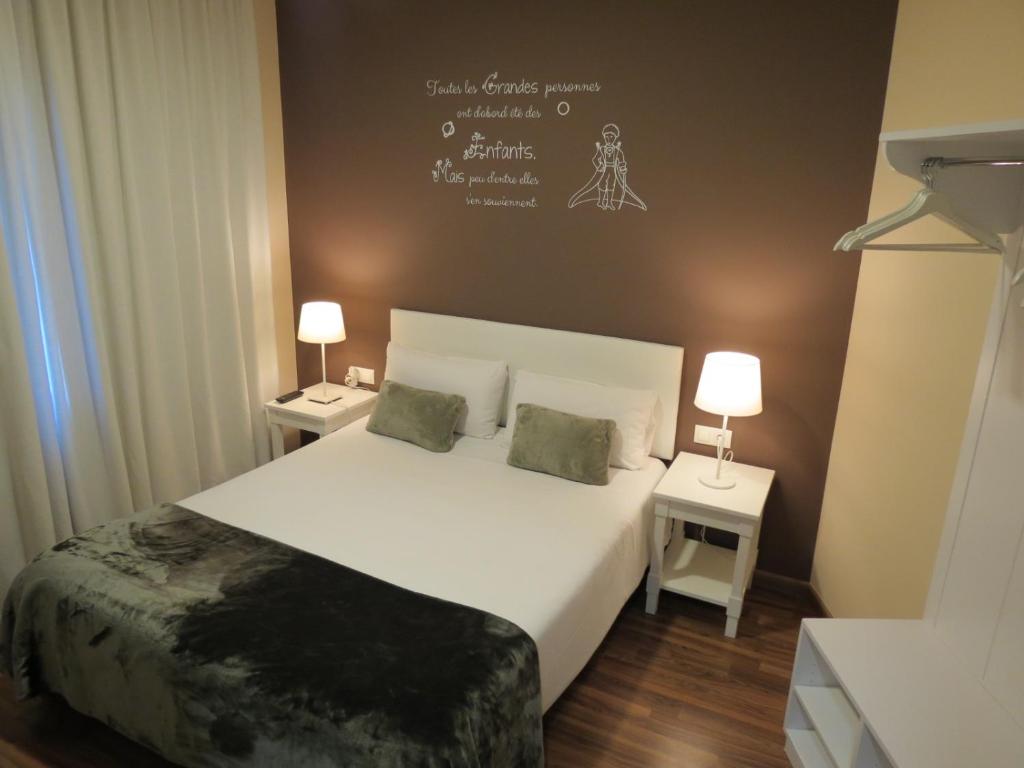 巴塞罗那佩蒂特普里塞普旅馆的一间卧室设有一张大床和两个床头柜