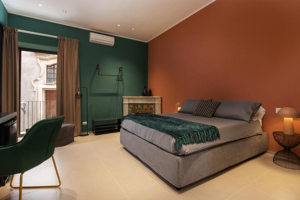卡塔尼亚La Regina del Duomo Catania Centro的一间卧室设有一张床和绿色的墙壁