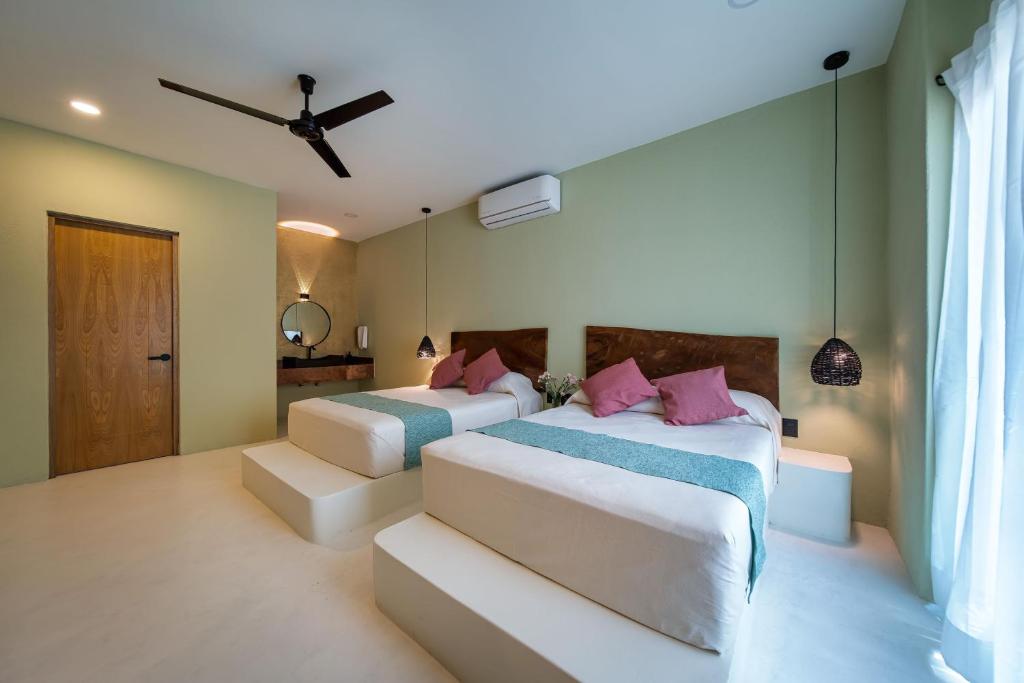 圣克鲁斯华特库Hotel Bindani’的一间卧室配有两张床和吊扇