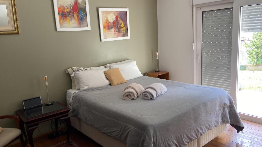 库里提巴Suite residencial, Villa da Luz的一间卧室配有一张床,上面有两条毛巾