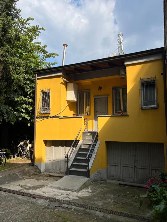米兰Gionas - Casa indipendente in zona strategica的黄色房子,设有楼梯和车库