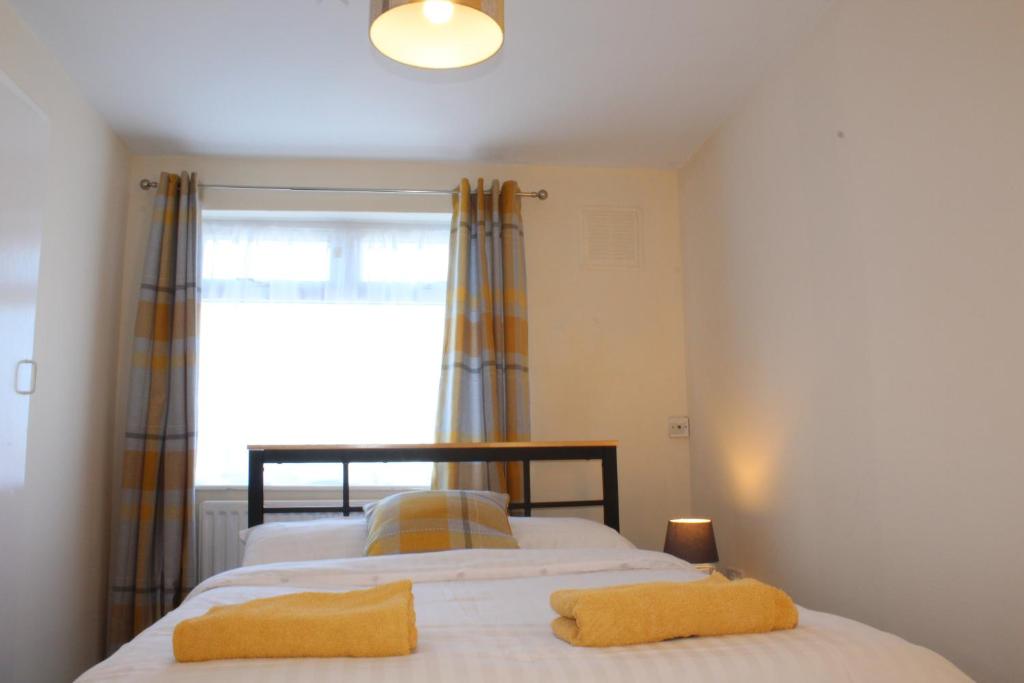 JarrowSunny South Shields House的一间卧室配有一张带两张黄色毛巾的床