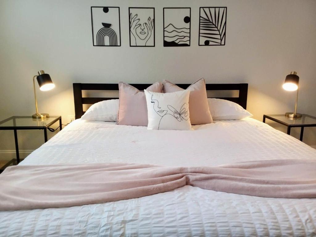 代托纳海滩"Two Bella" Luxury Apt - POOL - 4 Mi to Beach的卧室配有带枕头和两盏灯的白色床。