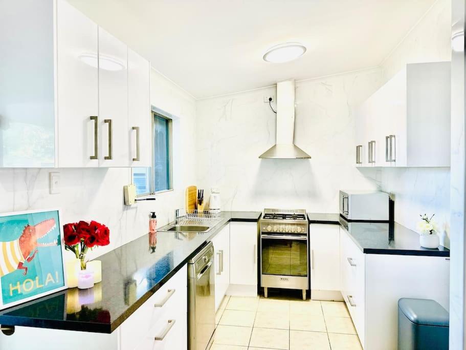 艾利斯斯普林斯Grabber- Three bedroom charm in Alice Springs的厨房配有白色橱柜和黑色台面