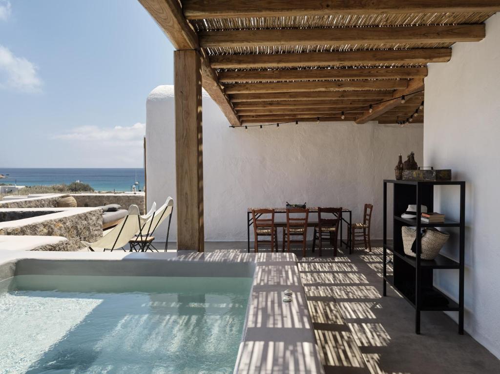 凯勒里瓦迪Nomad Mykonos - Small Luxury Hotels of the World的一个带游泳池和桌子的别墅