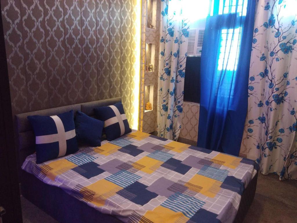 贾姆穆ASHIANA HOME STAY的一间卧室配有一张带五颜六色被子的床
