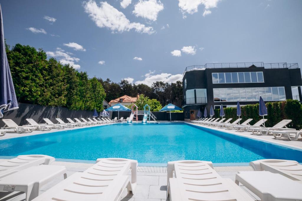 YelikhovichiAvalon Hotel&Pool的一座带躺椅的游泳池和一座建筑