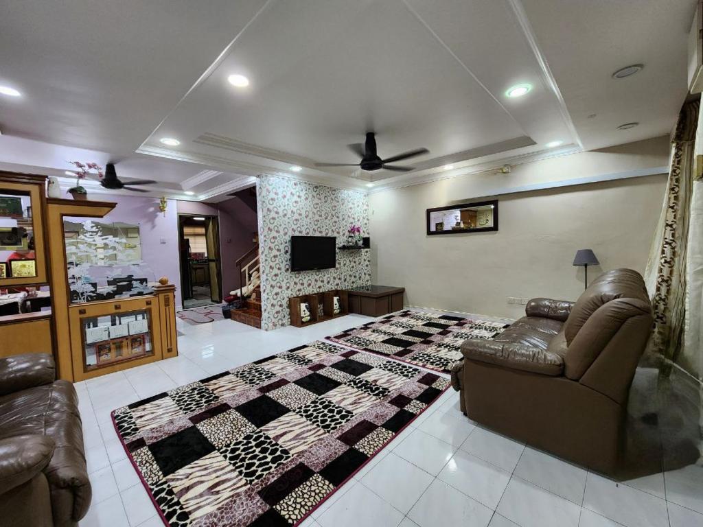 北赖Homestay Taman Pauh Jaya, Seberang Perai, Bukit Mertajam的带沙发、床和电视的客厅