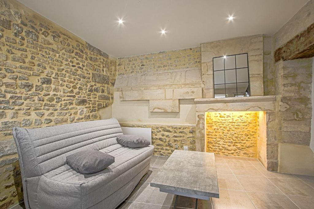 贝叶La cour des teinturiers的带沙发和石墙的客厅