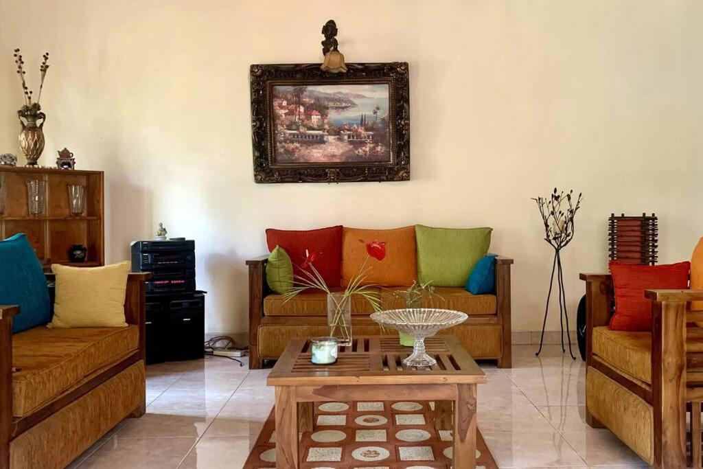 康提Dili's Home Stay的客厅配有两张沙发和一张桌子