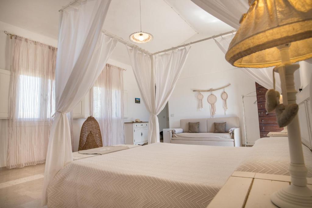 佩斯科勒海滨Antica Masseria Ficazzana - Tenuta的白色卧室配有两张床和一张沙发