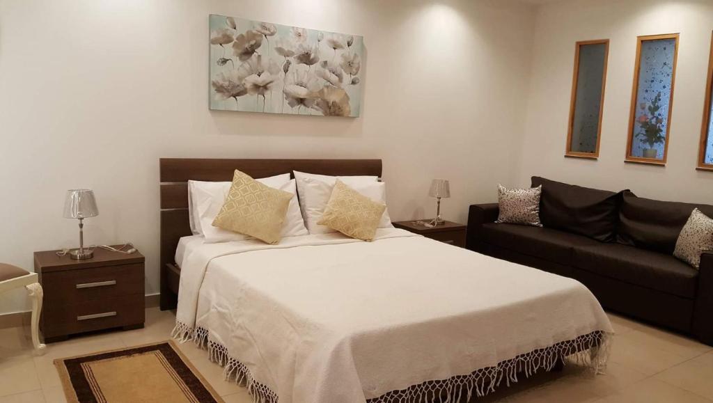 马尔萨什洛克White Pearl Apart 5的一间卧室配有一张大床和一张沙发