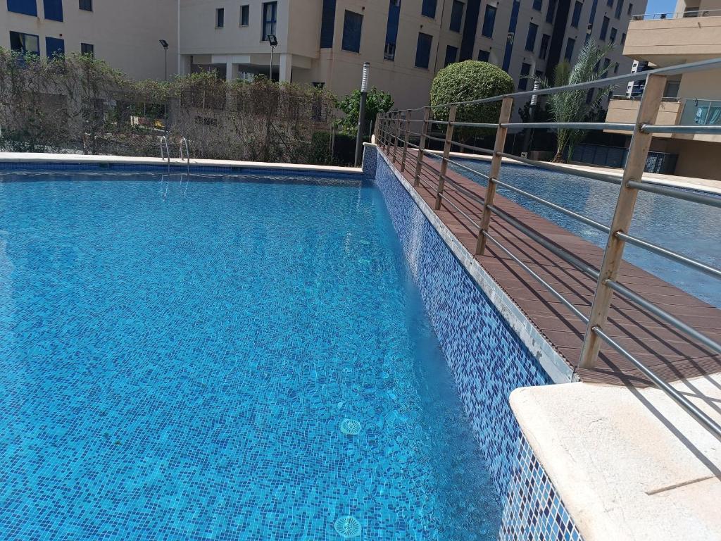 卡拉德费斯特拉特Fantástico apartamento playa的一座大型蓝色游泳池,位于大楼旁边