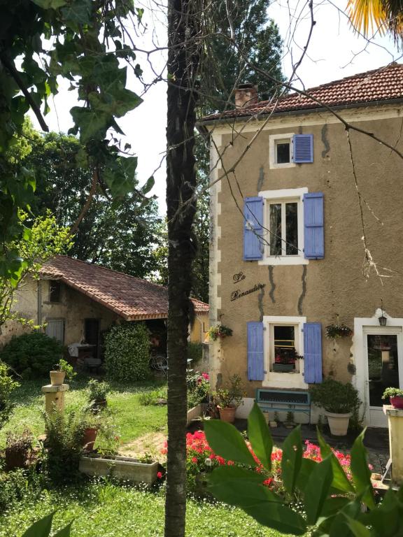 NassietLa RENAUDIERE的一座带蓝色百叶窗和鲜花的古老房子