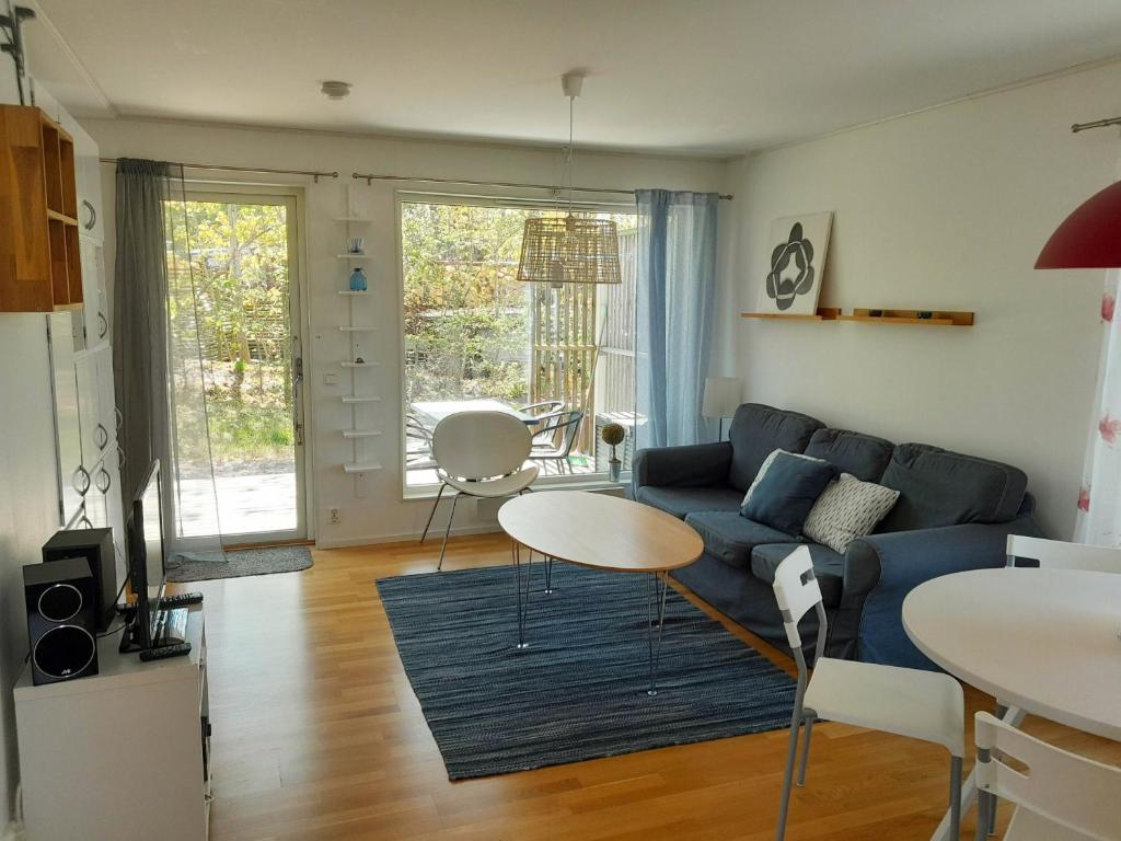 梅尔比斯特兰德Lovely holiday apartment in Mellbystrand的客厅配有蓝色的沙发和桌子