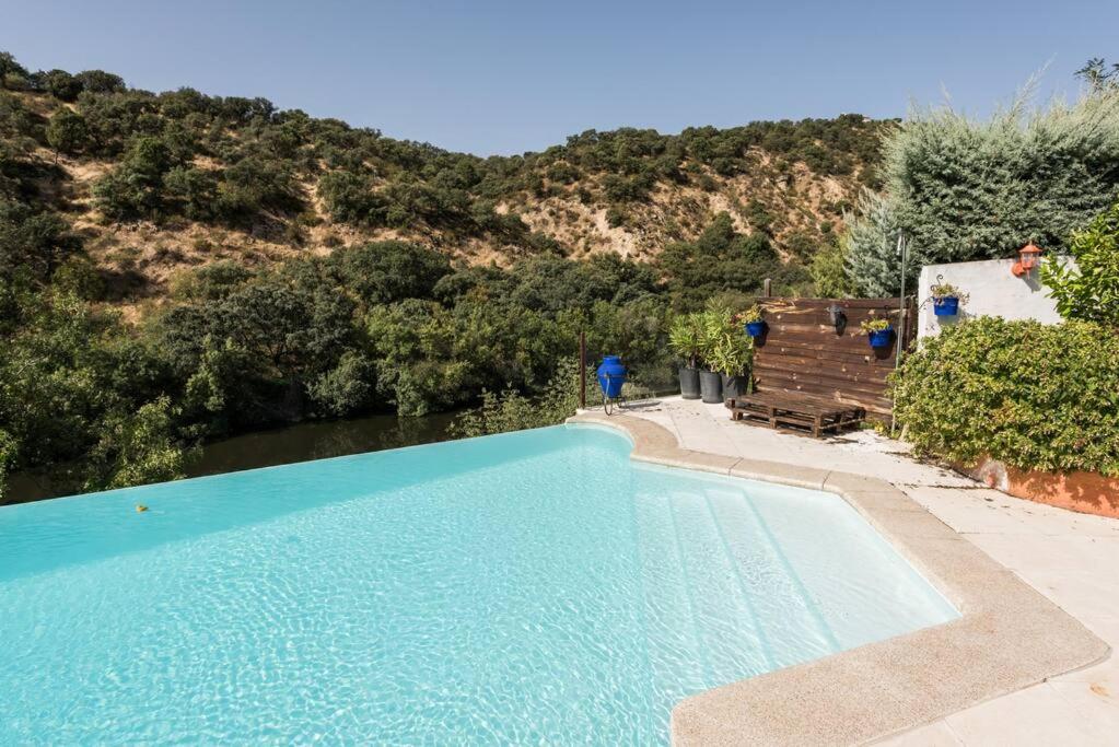 拉斯·罗萨斯·德·马德里Casa con vistas increíbles, piscina Infinity y jardín con rincones preciosos的毗邻山脉的大型蓝色游泳池
