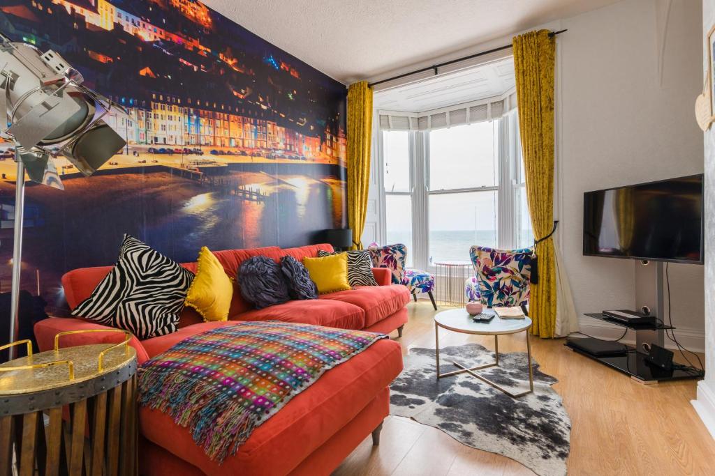 阿伯里斯特威斯Sea view Ar Lan y Mor LUXURY APARTMENT的客厅配有红色沙发和电视