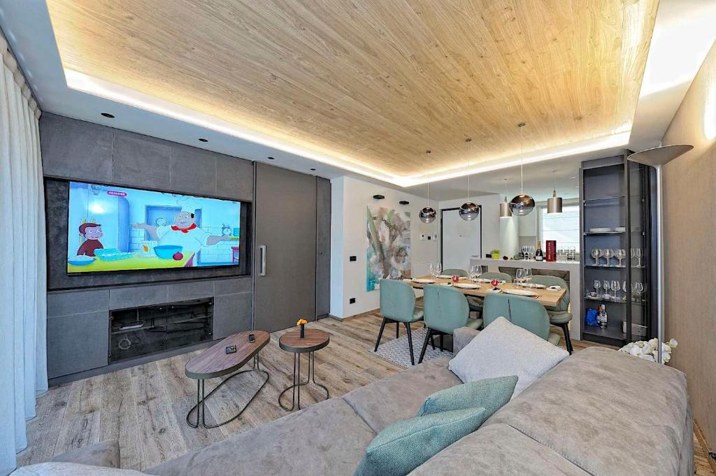 平佐洛Lux Domotic Apt-Chalet Dolomites的带沙发、电视和桌子的客厅