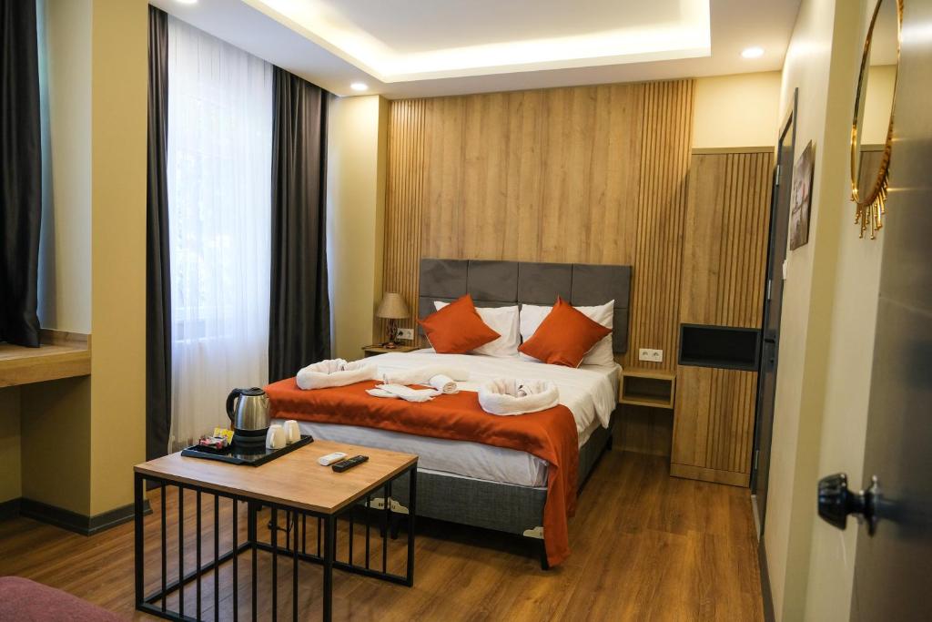 伊斯坦布尔hotel La Vitrine的一间卧室配有带橙色枕头和桌子的床