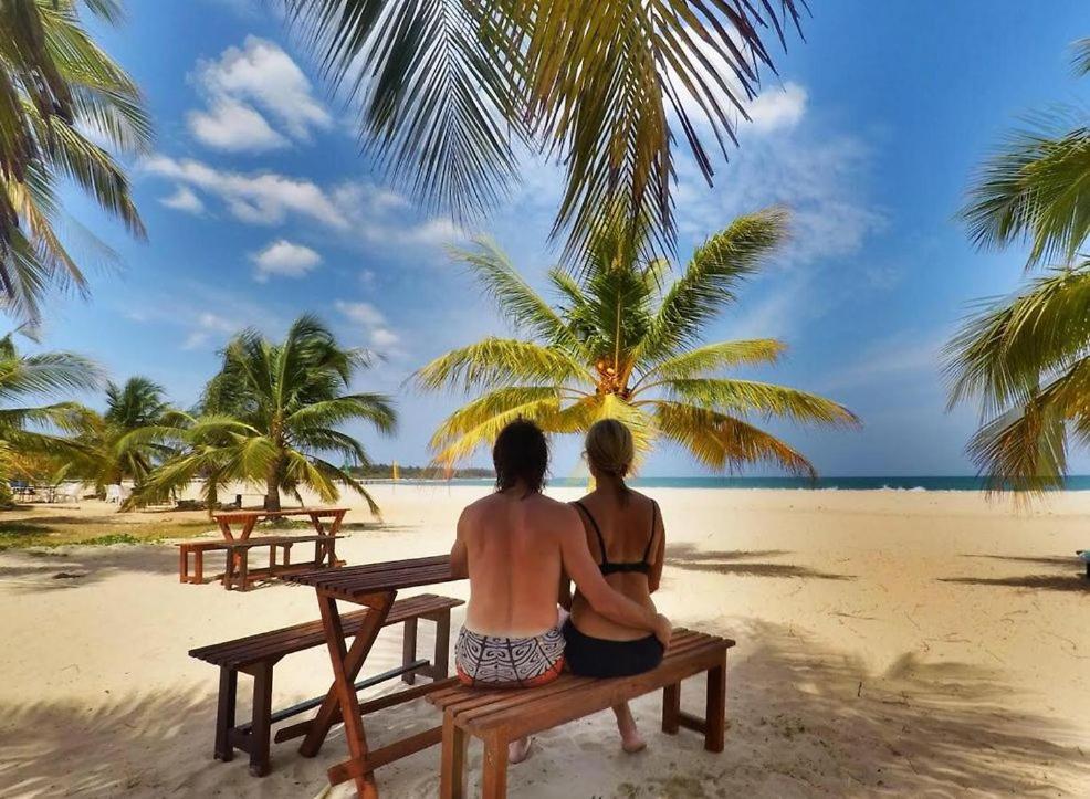 卡尔库达Aqua Marine Beach Hotel的两人坐在海滩上的长凳上
