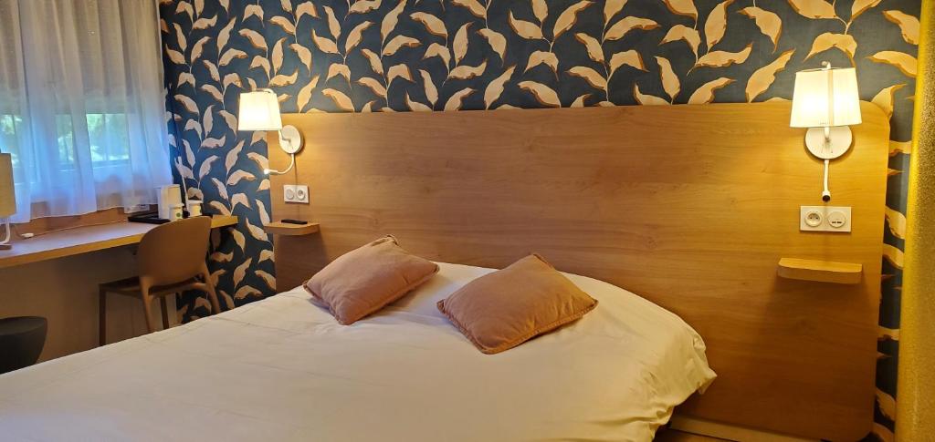翁弗勒尔KYRIAD HONFLEUR - La Riviere Saint Sauveur的一间卧室配有一张带两个枕头的床
