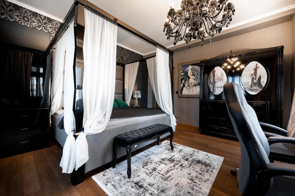科希策Premium Apt Kosice Center 3 room with PARKING的一间卧室配有一张天蓬床、椅子和吊灯