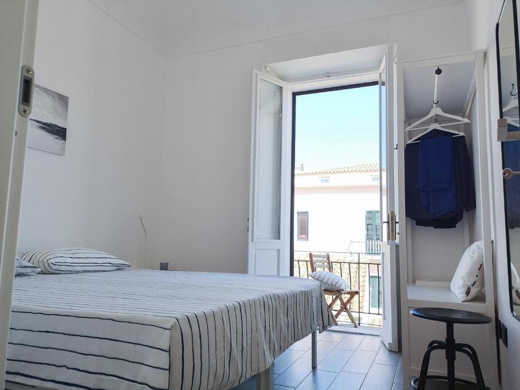 马达莱纳DomoMea - L'Isola nell'Isola的一间白色卧室,配有床和阳台