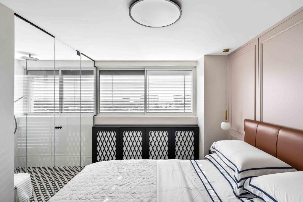 荷兹利亚Elegant Beachfront Duplex with Private Parking的一间卧室设有一张床和一个玻璃淋浴间