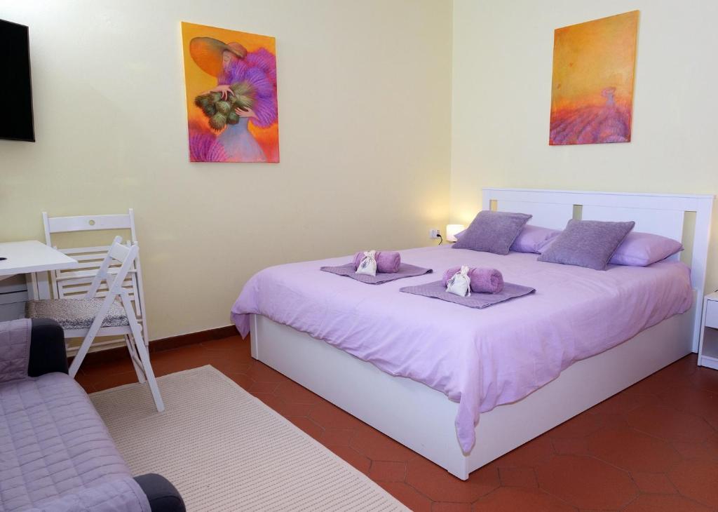 DekaniLavanderin Apartment的卧室配有一张大白色床和紫色床单