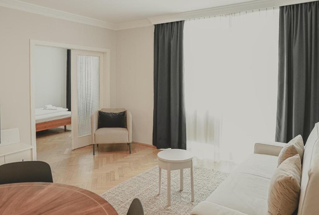 维也纳瑞典广场亥米公寓的白色的客厅配有桌子和椅子