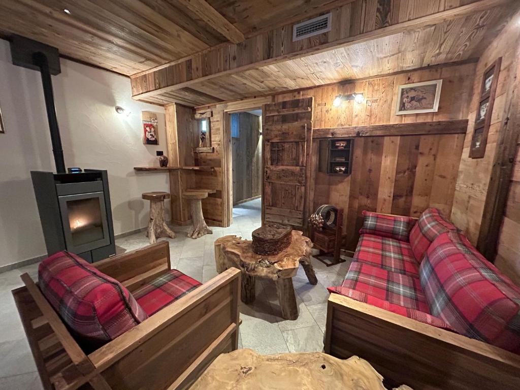 科涅HIBOU chambres & spa - Cogne的小屋内的客厅配有沙发和壁炉