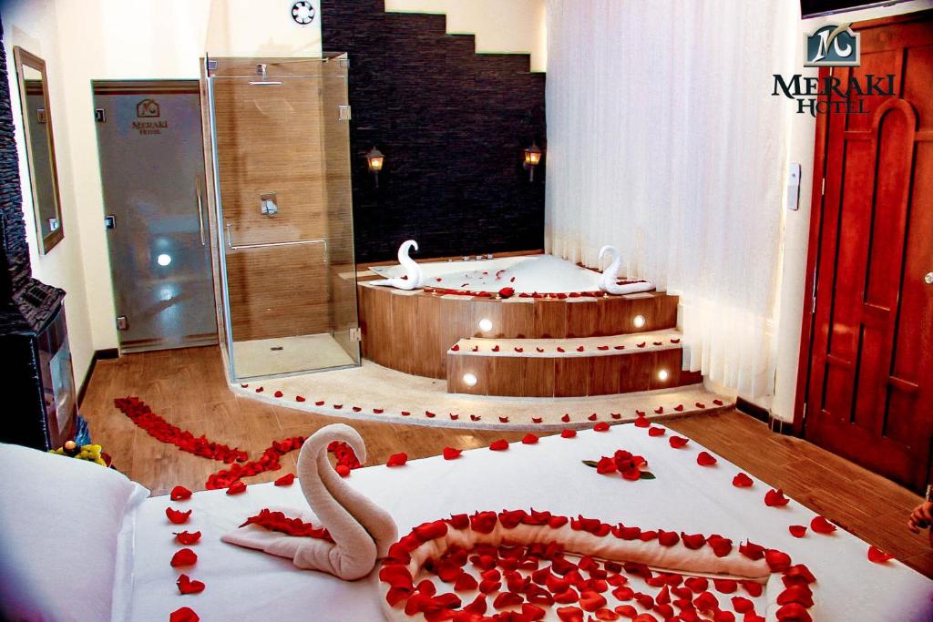 巴尼奥斯Meraki Hotel的一间设有浴缸的客房,配有玫瑰蛋糕