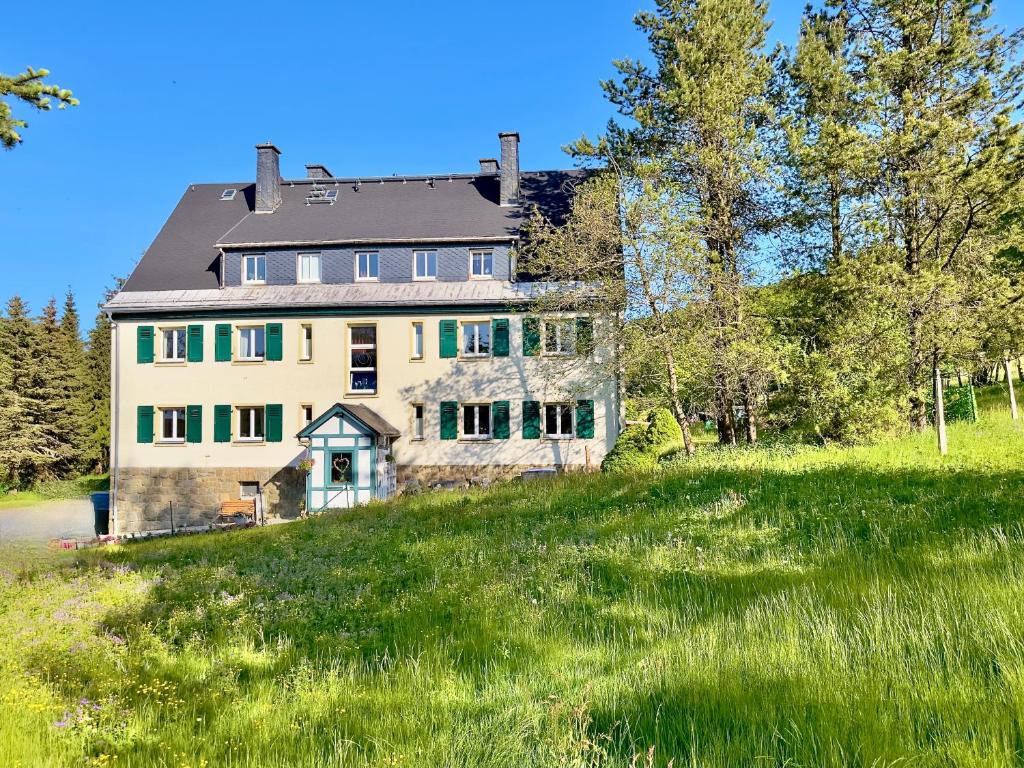 库罗阿尔滕堡Haus Donnerberg Rehefeld的一座绿草丛生的小山上的大房子