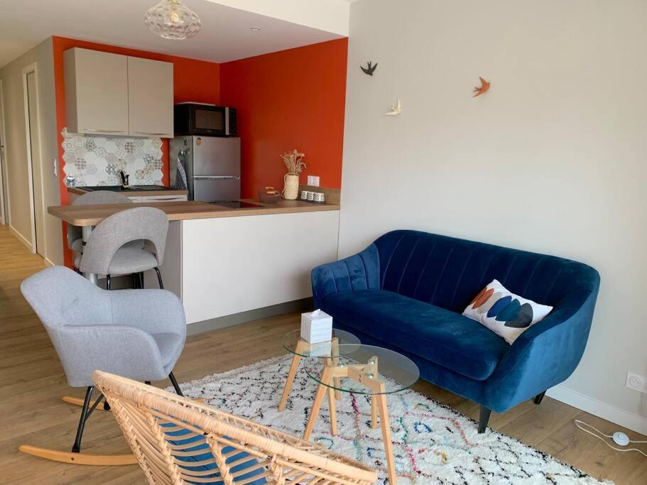 邦多勒T2 avec garage possible, port et plage à moins de 5 minutes à pied !的一间带蓝色沙发的客厅和一间厨房