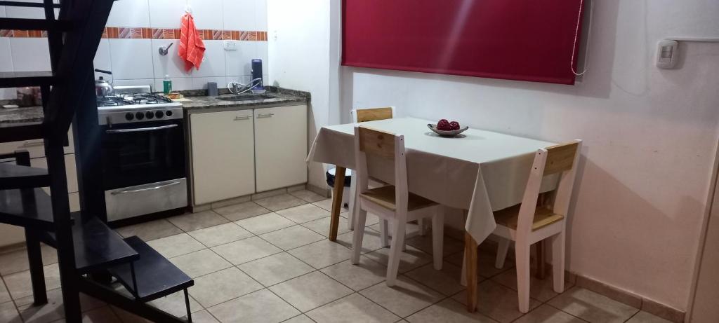 Villa BallesterDpto económico para tres en Ballester con TV的厨房配有桌椅和炉灶。